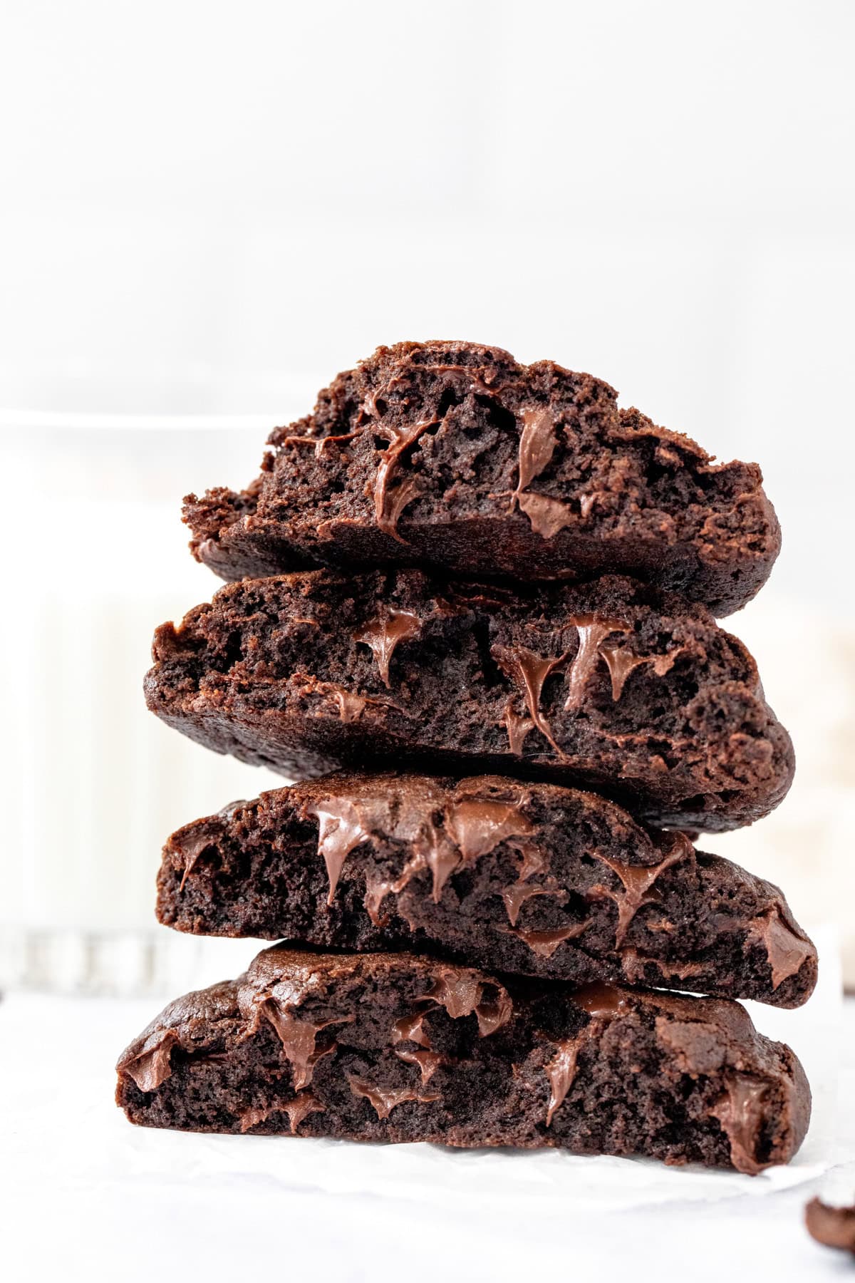Extra thick bakery style double chocolate chip cookies broken in half and stacked on top of one another