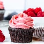 Chocolate cupcake with raspberry frosting with muffin paper peeled off