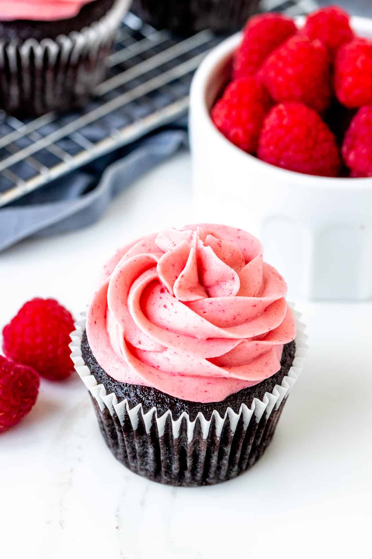 Chocolate raspberry cupcake with small bowl of berries