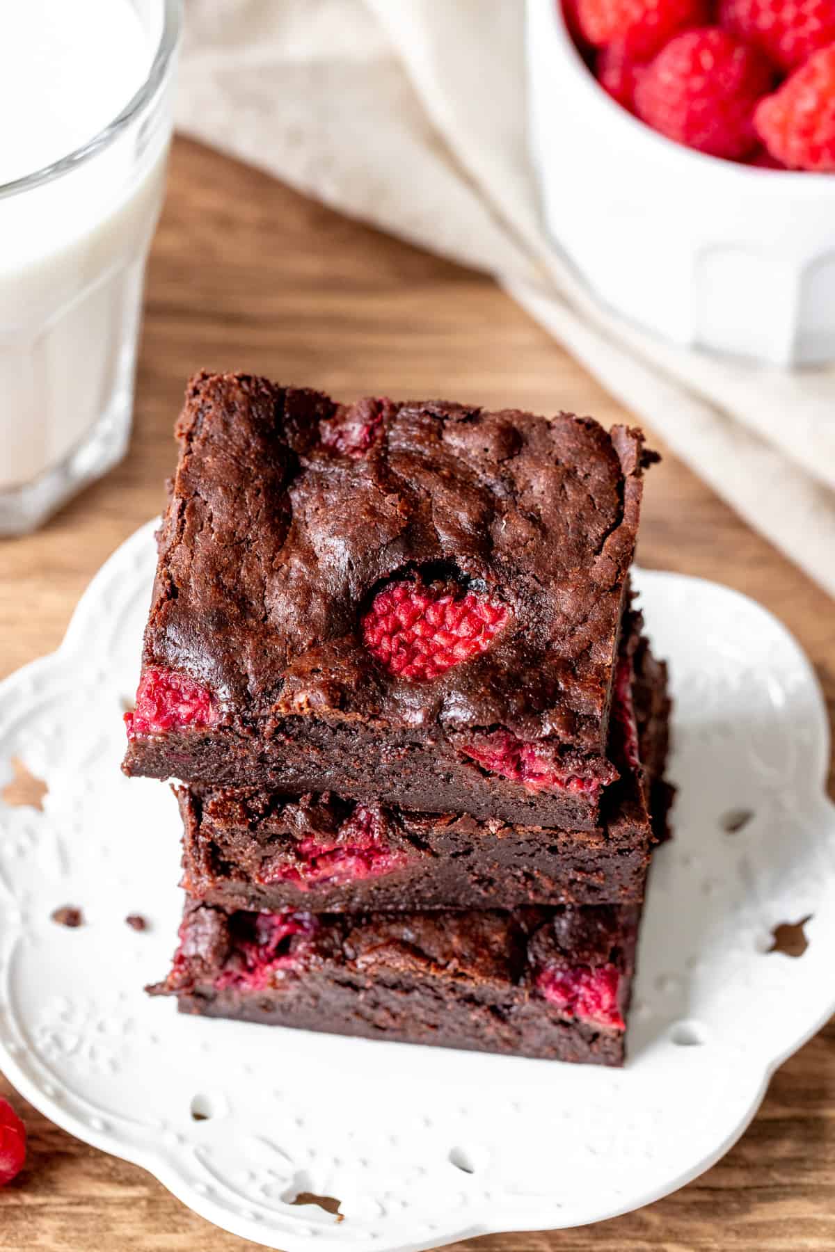 Three brownies studded with raspberries, stacked on top of eachother