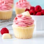 White chocolate cupcake with raspberry frosting with square of white chocolate on top