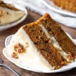 Slice of carrot cake layer cake with cream cheese frosting
