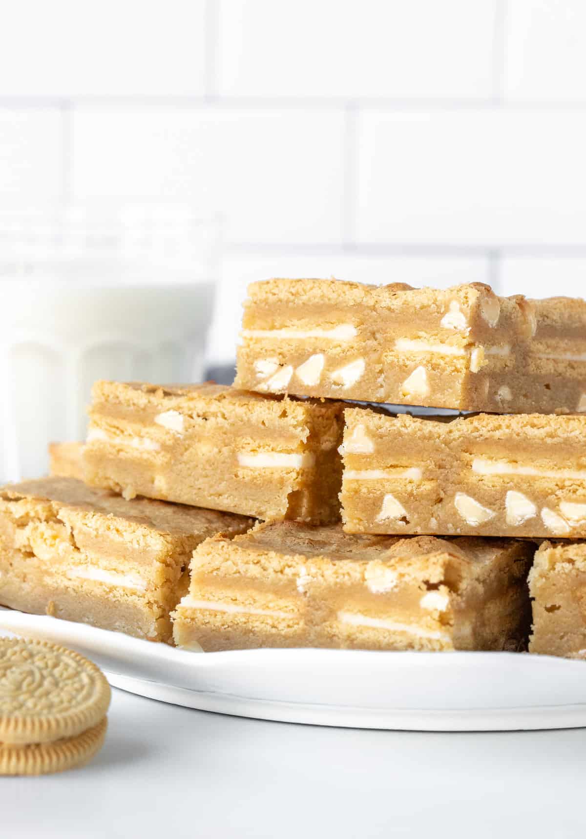 Plate of golden Oreo blondies, stacked on top of each other. 
