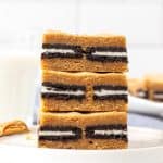 Stack of three peanut butter Oreo blondies with glass of milk