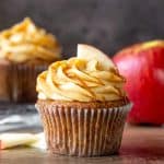 Apple cupcake topped with salted caramel frosting, a drizzle of caramel and a slice of apple