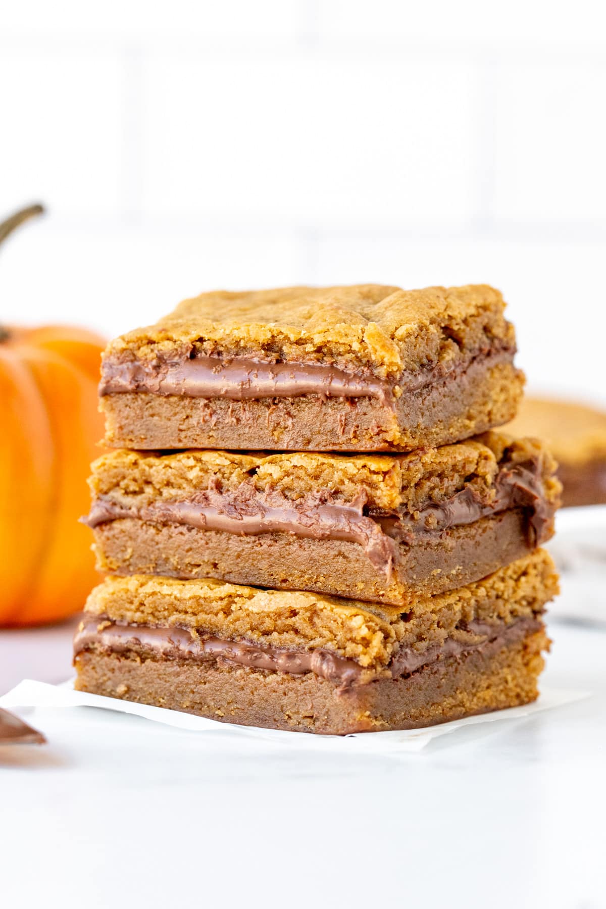 Three Nutella stuffed pumpkin blondies, stacked one on top of each other