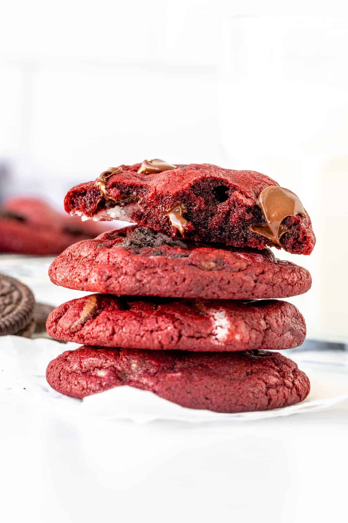 Stack or Oreo red velvet cookies, with top cookie broken in half.