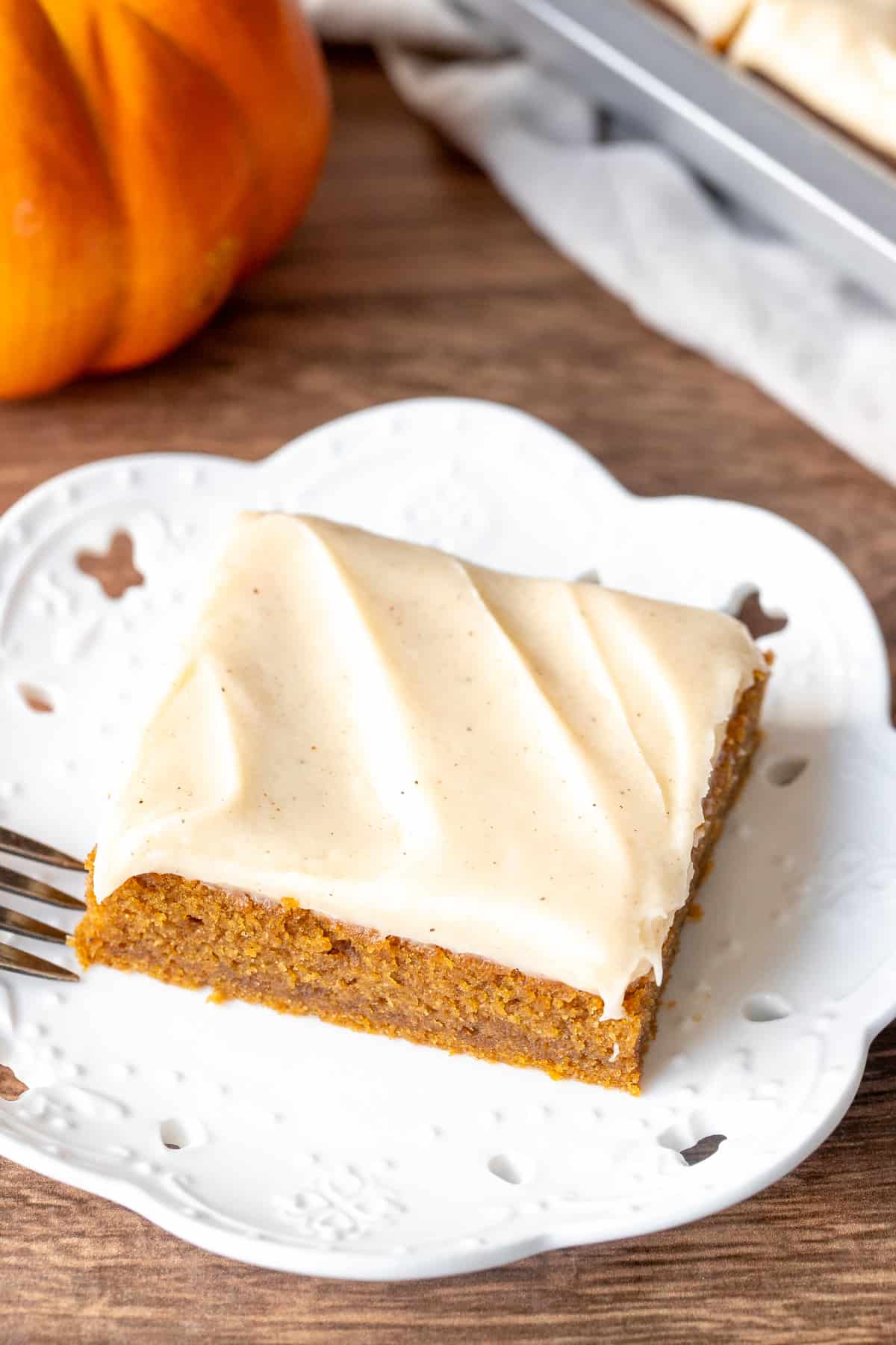 Pumpkin bar with cinnamon cream cheese frosting on a plate