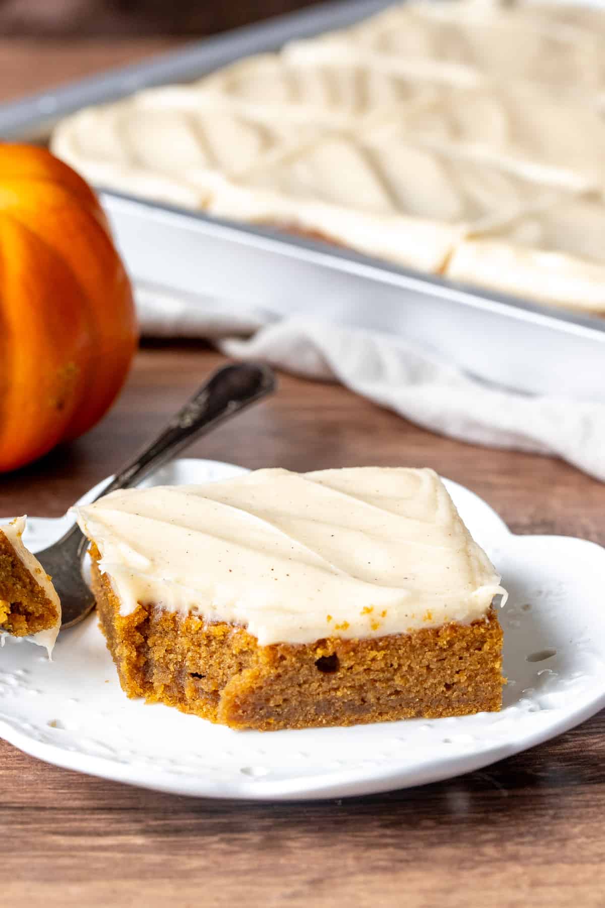 Pumpkin bar with cream cheese frosting with a bite taken out
