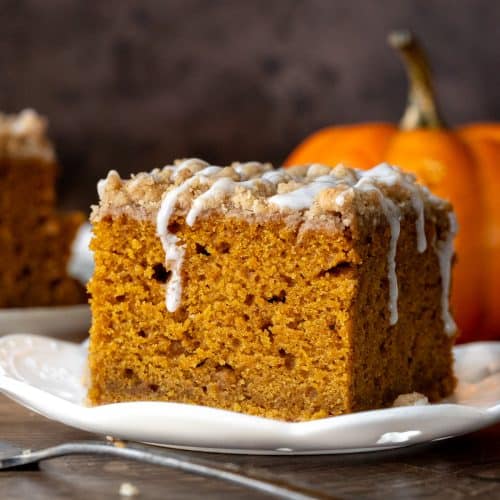 Slice of pumpkin coffee cake with streusel topping with a drizzle of glaze