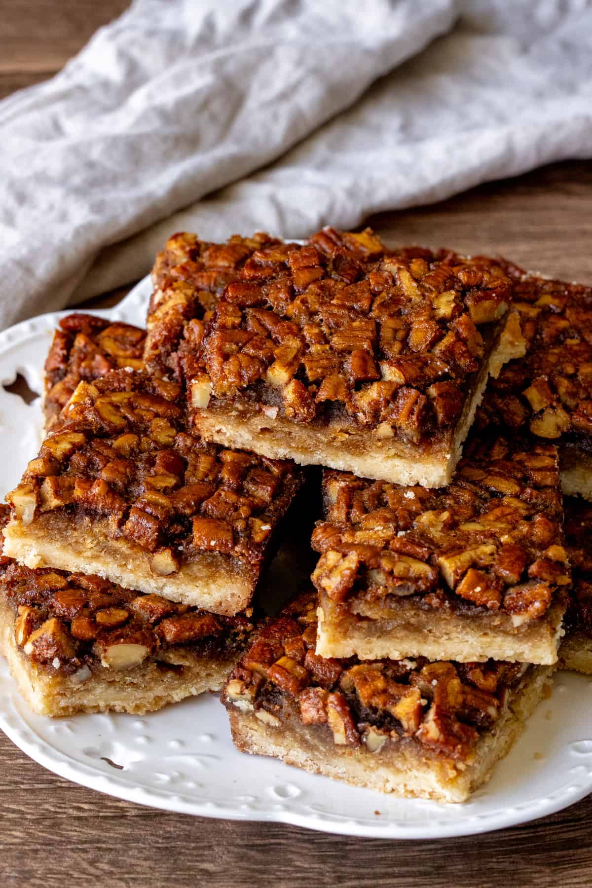 Plate of maple pecan shortbread bars, with bars stacked on top of each other