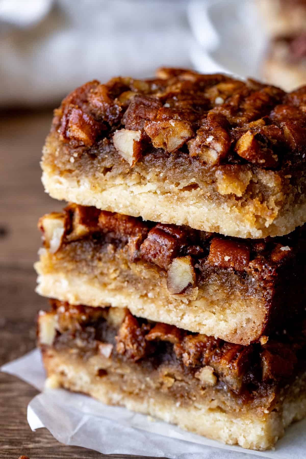 Three maple pecan pie bars, stacked one on top of each other.
