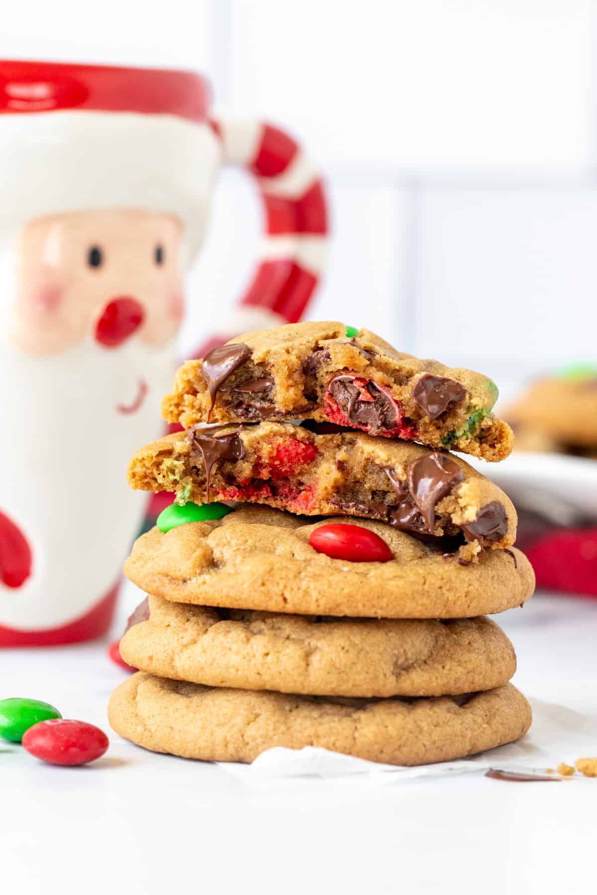 Stack of Christmas M&M peanut butter cookies, with top cookie broken in half