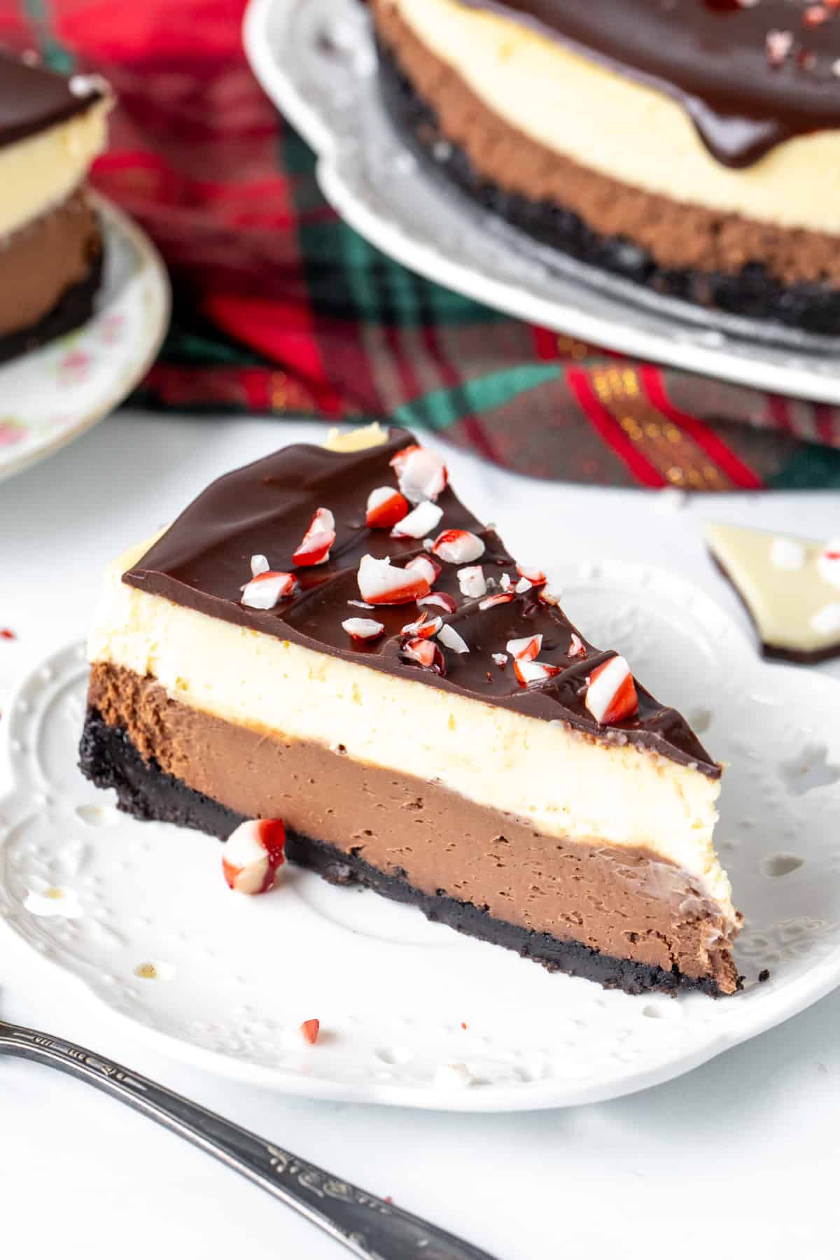 Slice of peppermint bark cheesecake on a white plate.