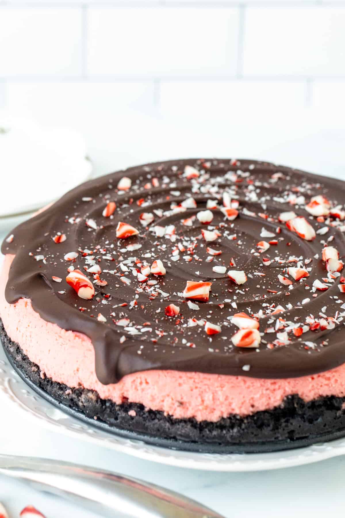 9-inch round peppermint cheesecake topped with chocolate ganache and crushed candy canes