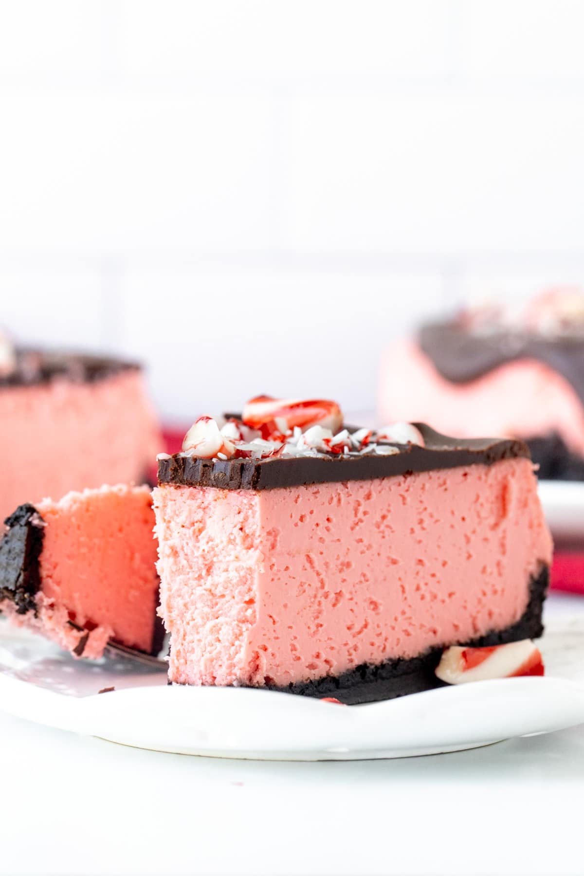 Slice of peppermint cheesecake on a plate with a bite taken out