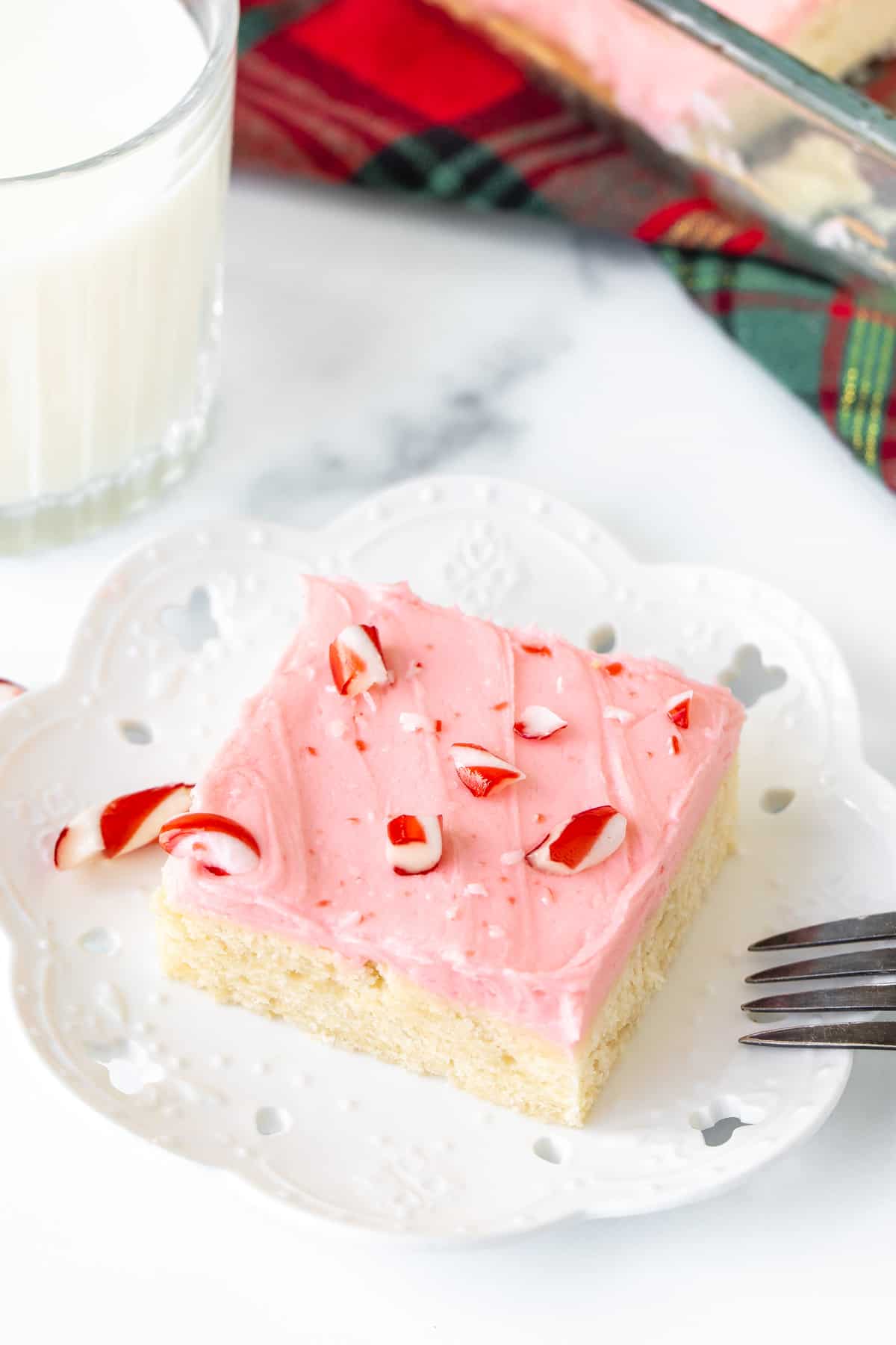 Slice of peppermint sugar cookie bars with glass of milk