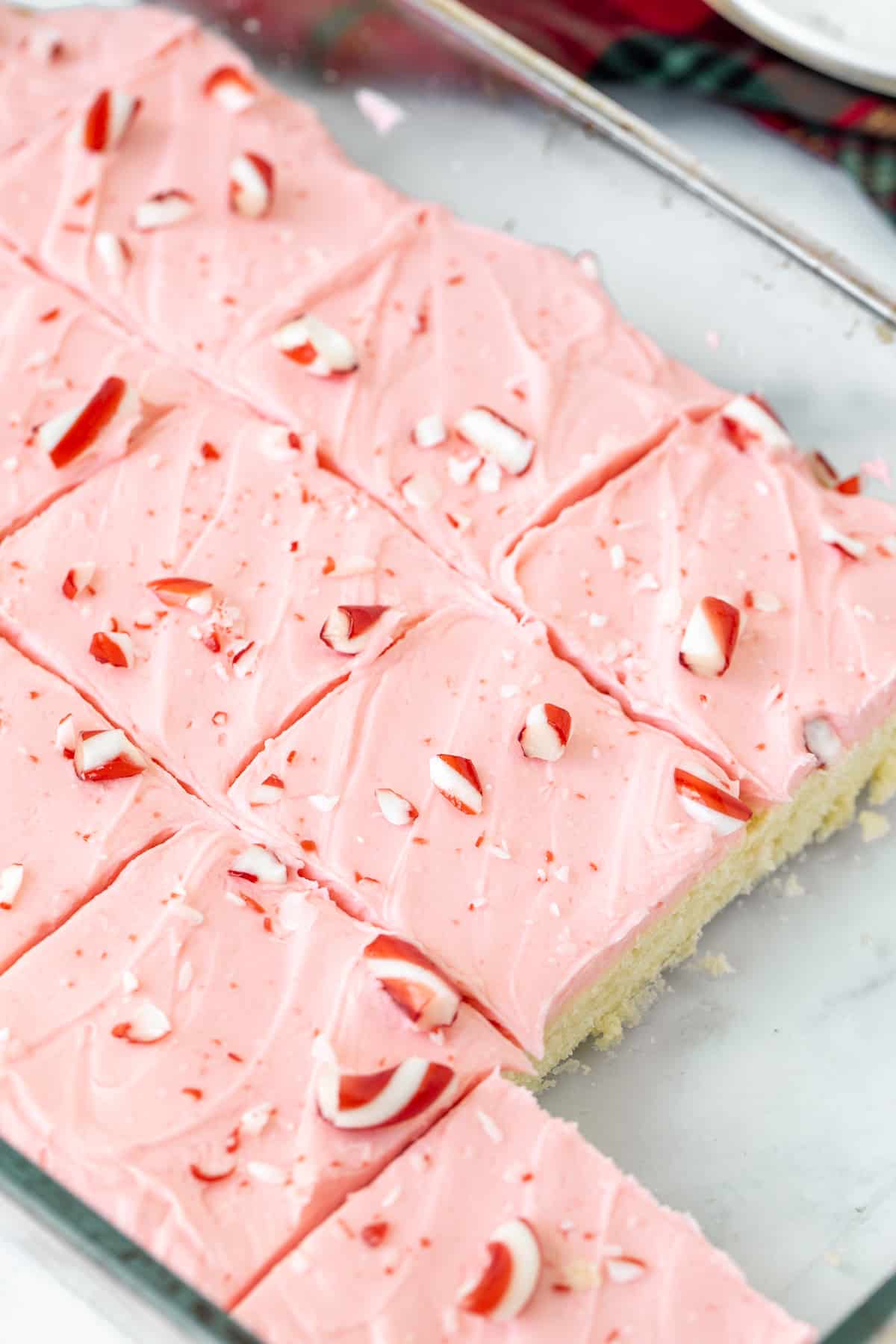 Pan of frosted peppermint sugar cookie bars with crushed candy canes on top