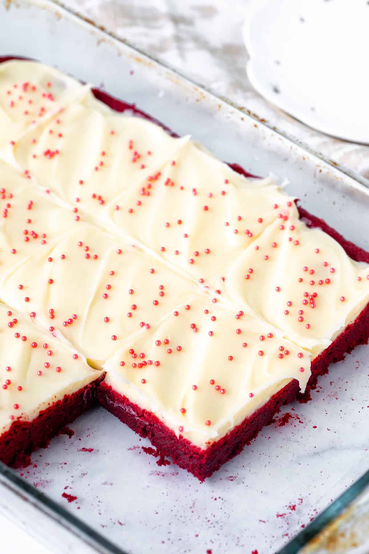 Pan of red velvet sugar cookie bars with frosting