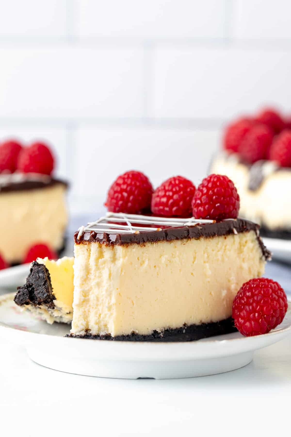 Slice of white chocolate raspberry cheesecake with bite taken out