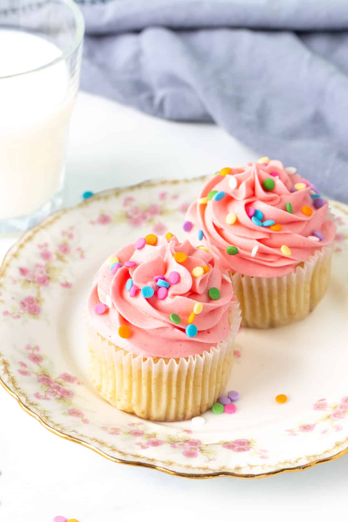 Vanilla cupcakes for two on a plate with glass of milk