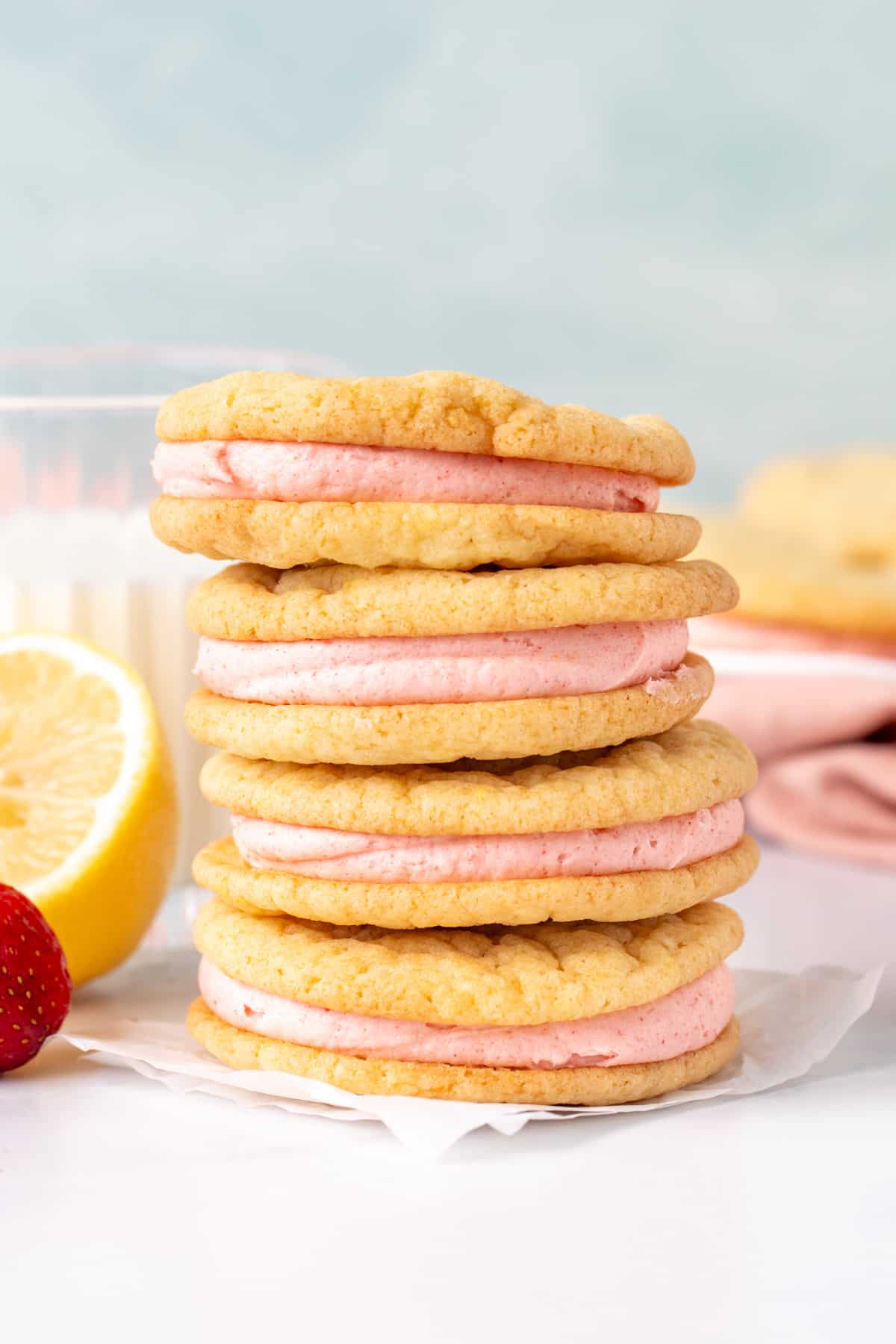 Stack of 4 lemon sandwich cookies with pink strawberry frosting