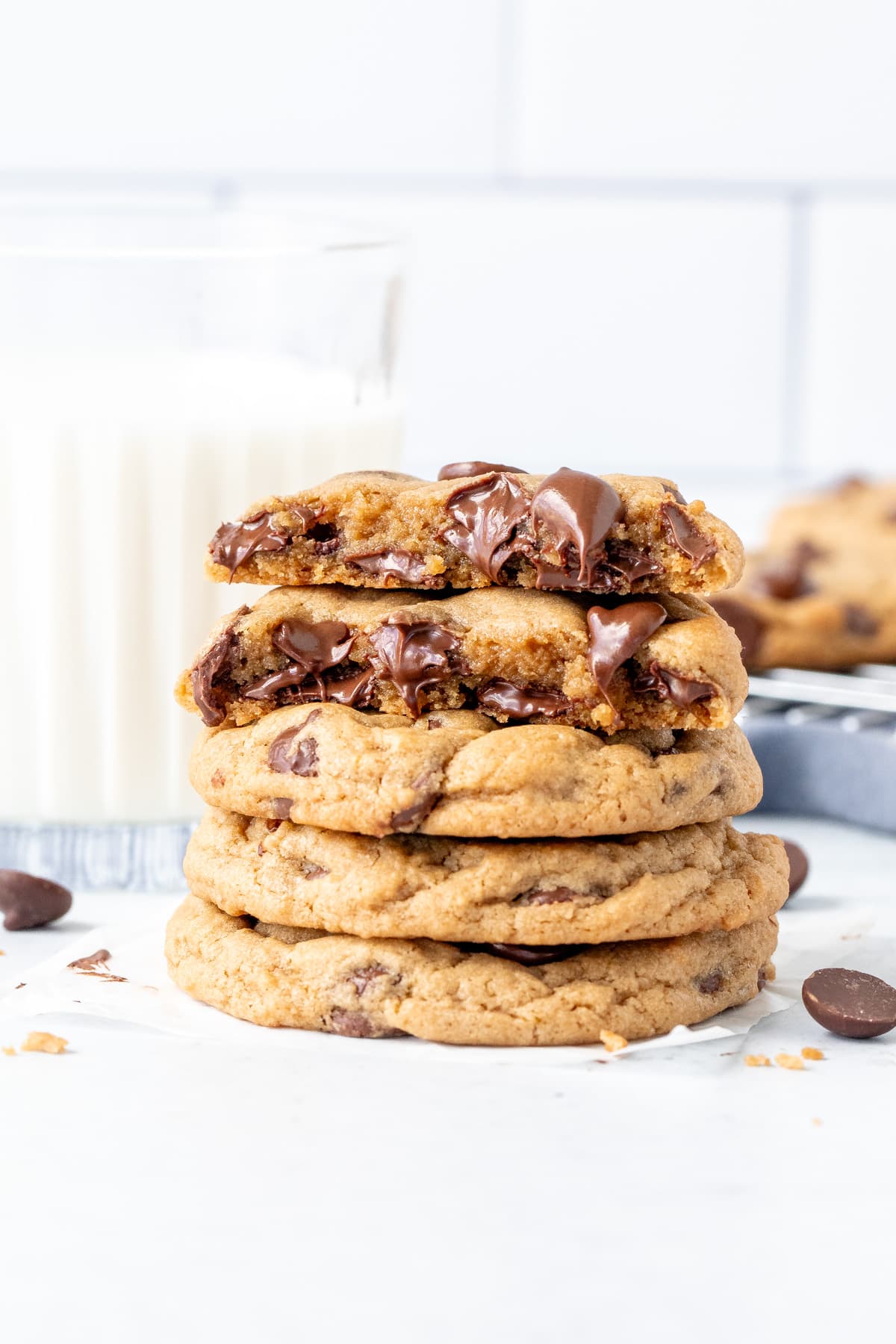 Stack of cream cheese chocolate chip cookies with top cookie broken in half.