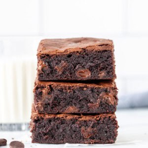 Stack of three brownies made with oil and cocoa and filled with chocolate chips