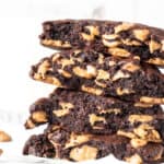 Stack of halves of dark chocolate peanut butter chip cookies.