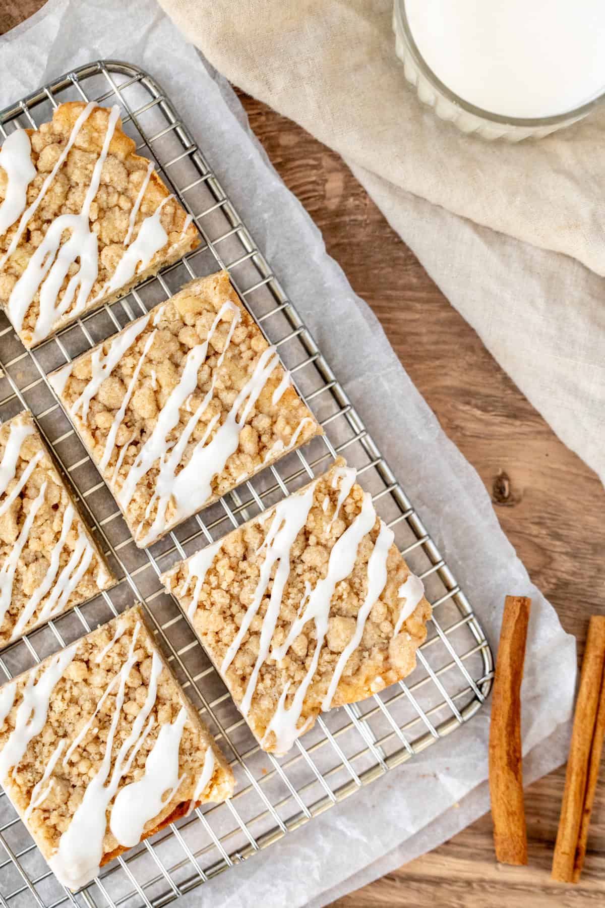 Blondies topped with cinnamon streusel and vanilla glaze on a cookie rack