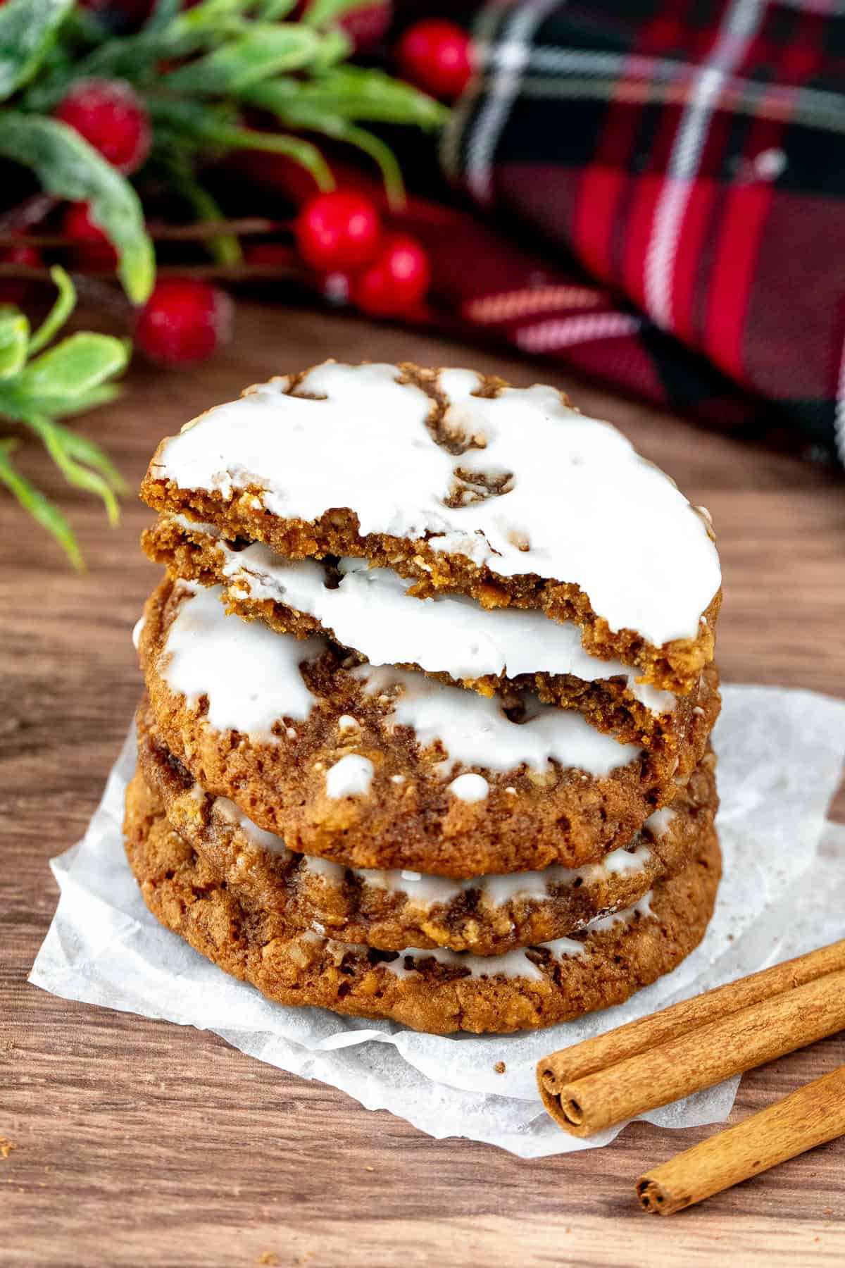 Stack of iced gingerbread oatmeal cookies, with top cookie broken in half.