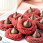 Plate of red velvet blossom cookies, each cookie topped with a Hershey's Kiss
