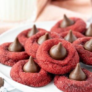 Plate of red velvet blossom cookies, each cookie topped with a Hershey's Kiss