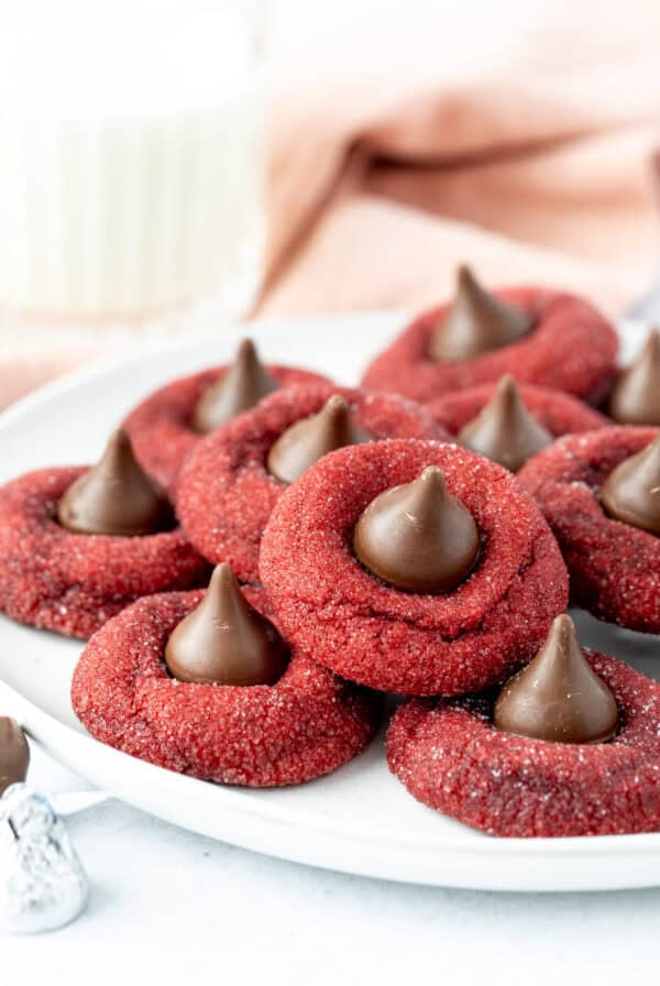 Plate of red velvet blossom cookies, each cookie topped with a Hershey's Kiss