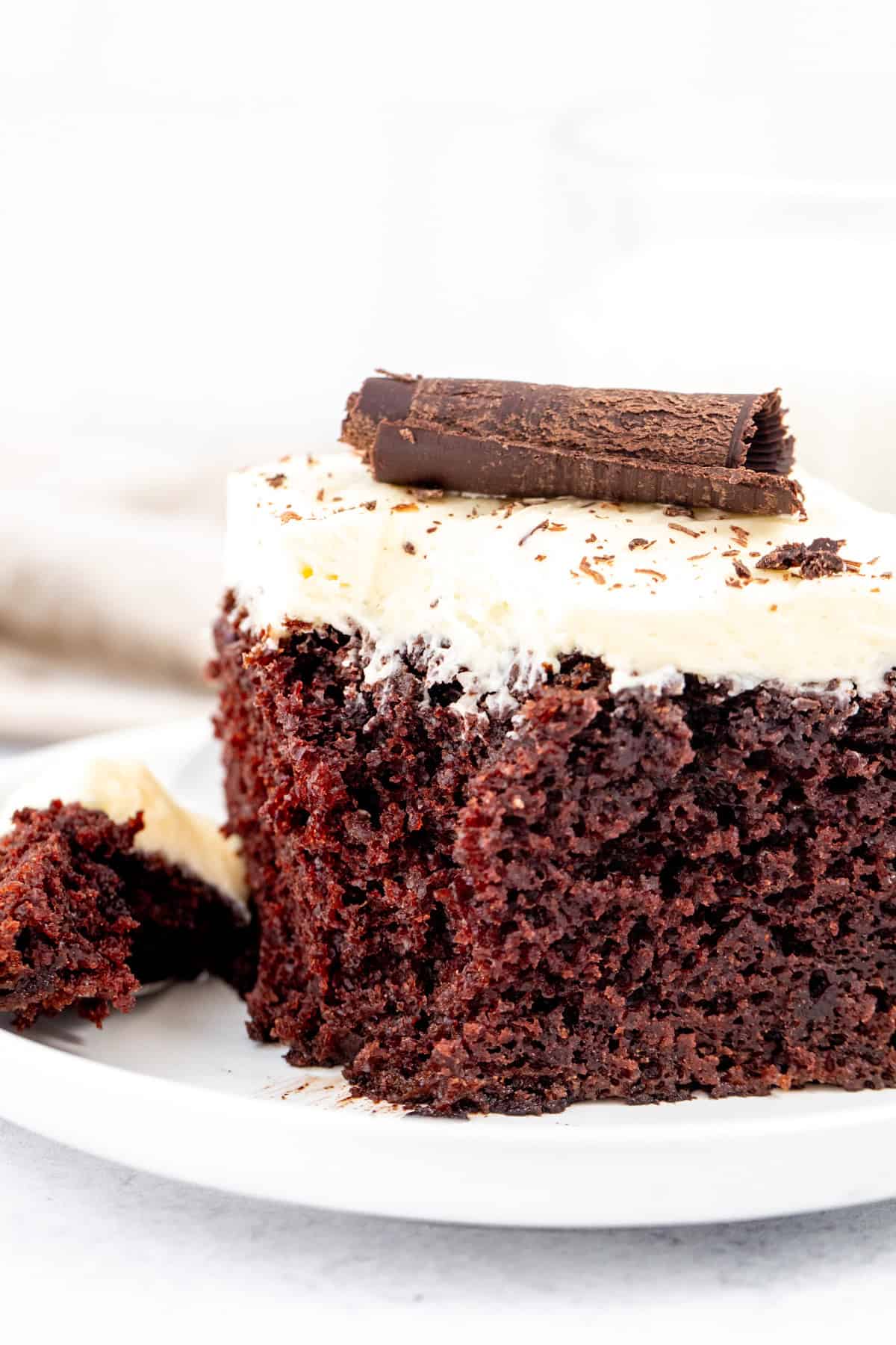 fudgy chocolate cake with white chocolate buttercream and a chocolate curl on top