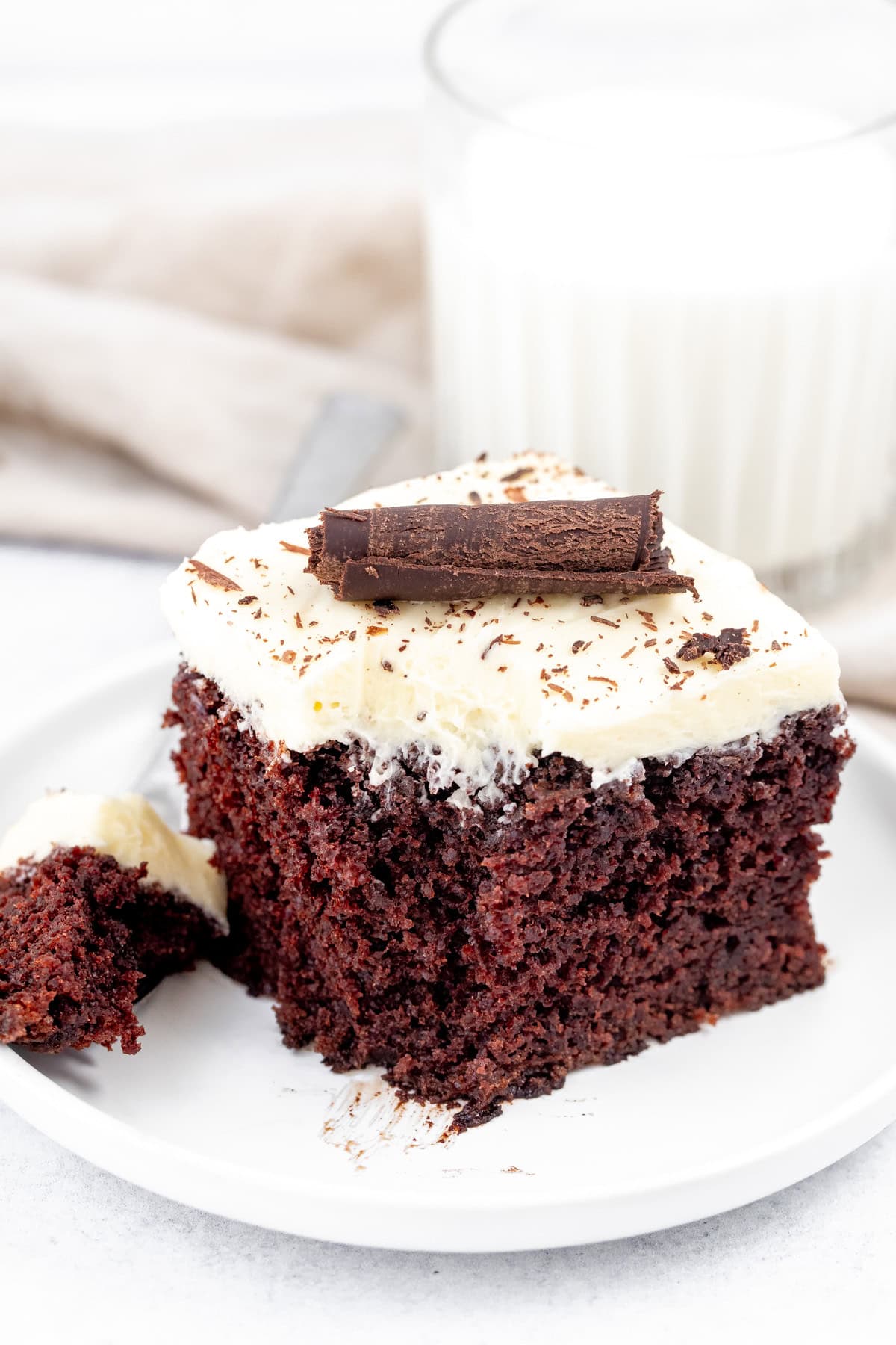 Square piece of chocolate cake sheet cake with white chocolate frosting with a bite taken out