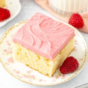 Slice of almond cake with raspberry frosting with a glass of milk