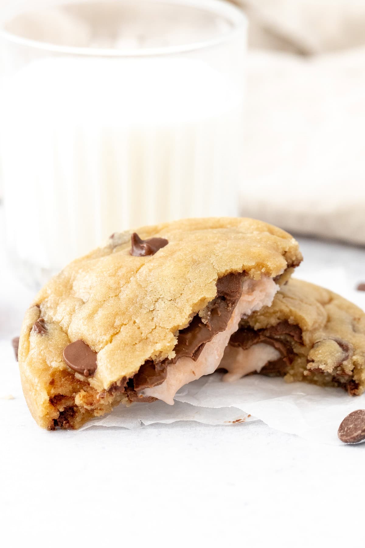 Cream Egg chocolate chip cookie, broken in half with glass of milk