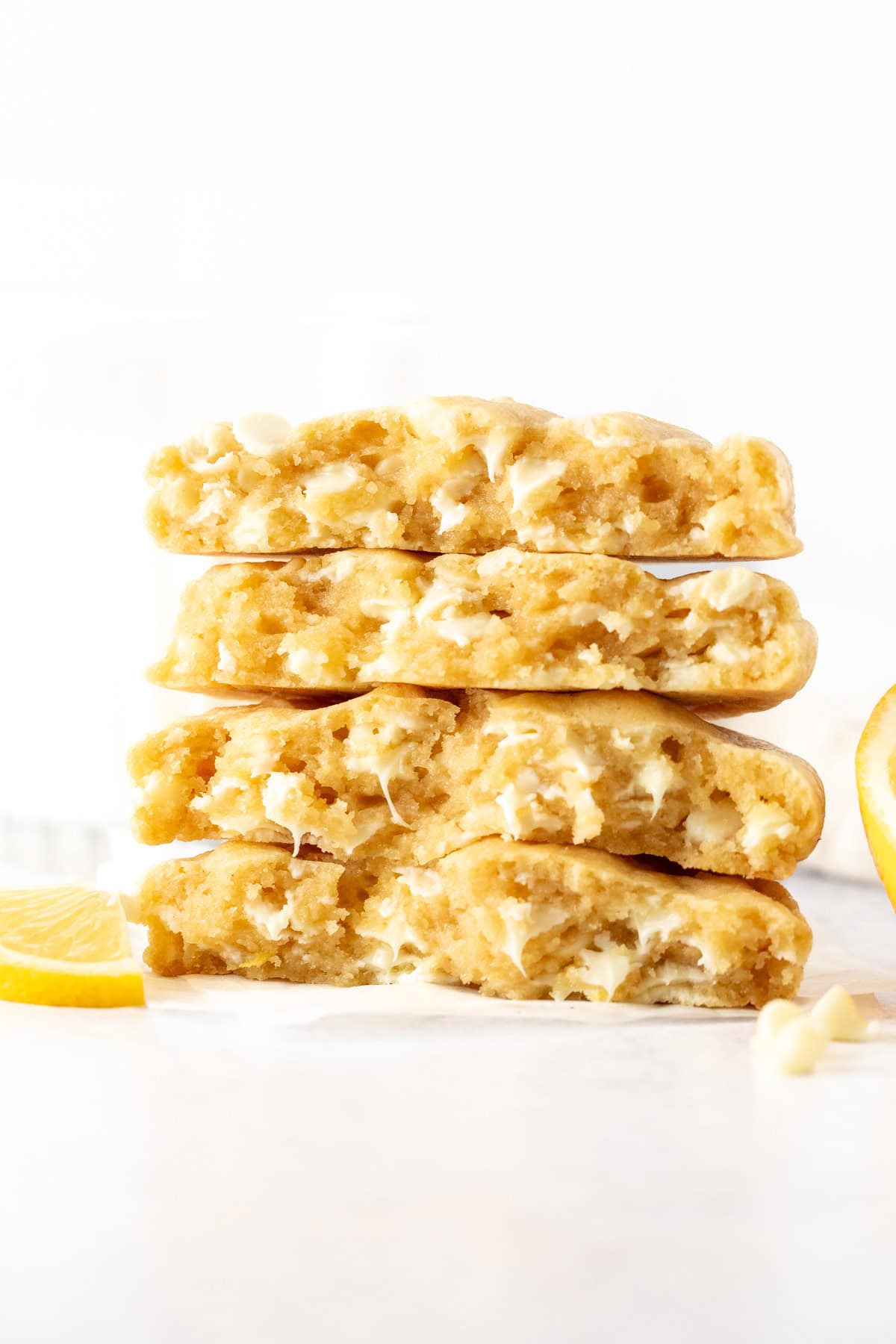 Stack of bakery-style lemon white chocolate chip cookies, broken in half