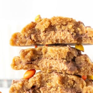 Peanut butter cookies stuffed with a peanut butter cup in the middle, broken in half and stacked on top of one another