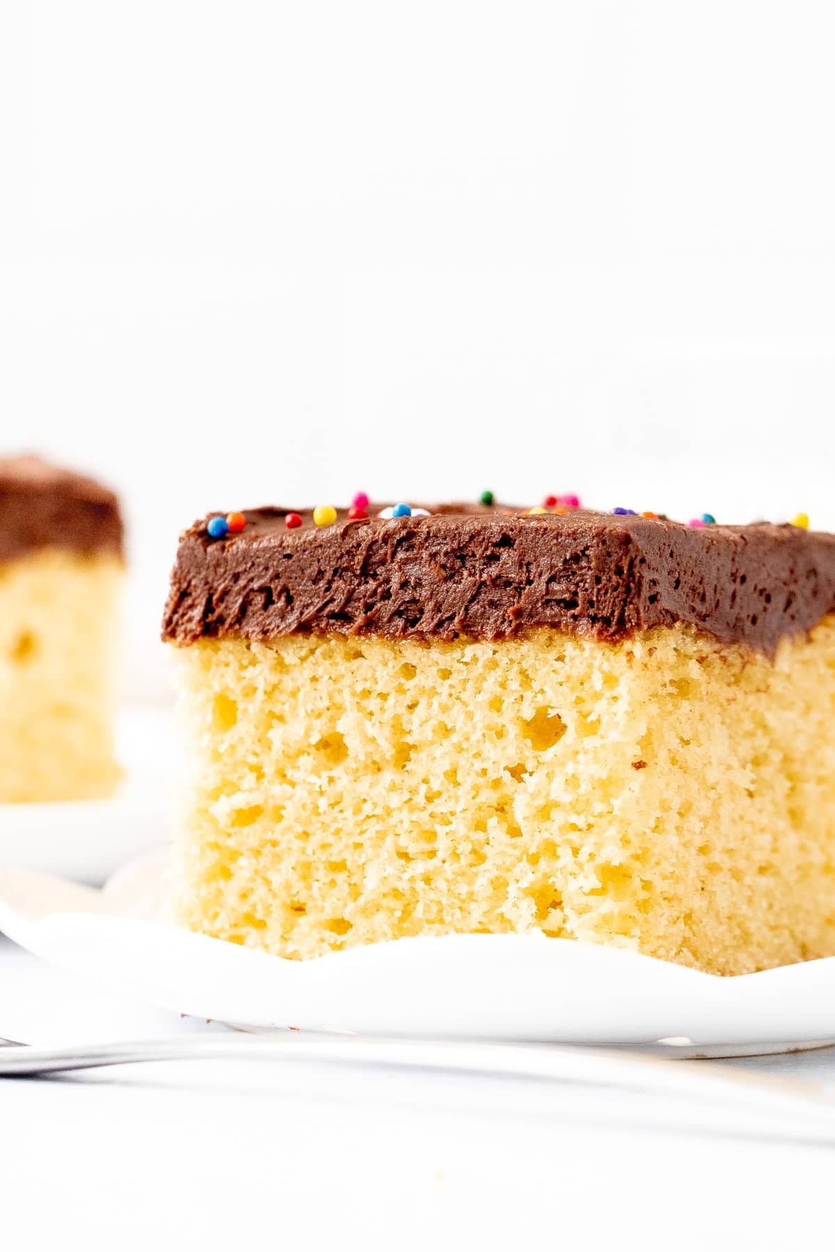Slice of yellow cake with chocolate frosting