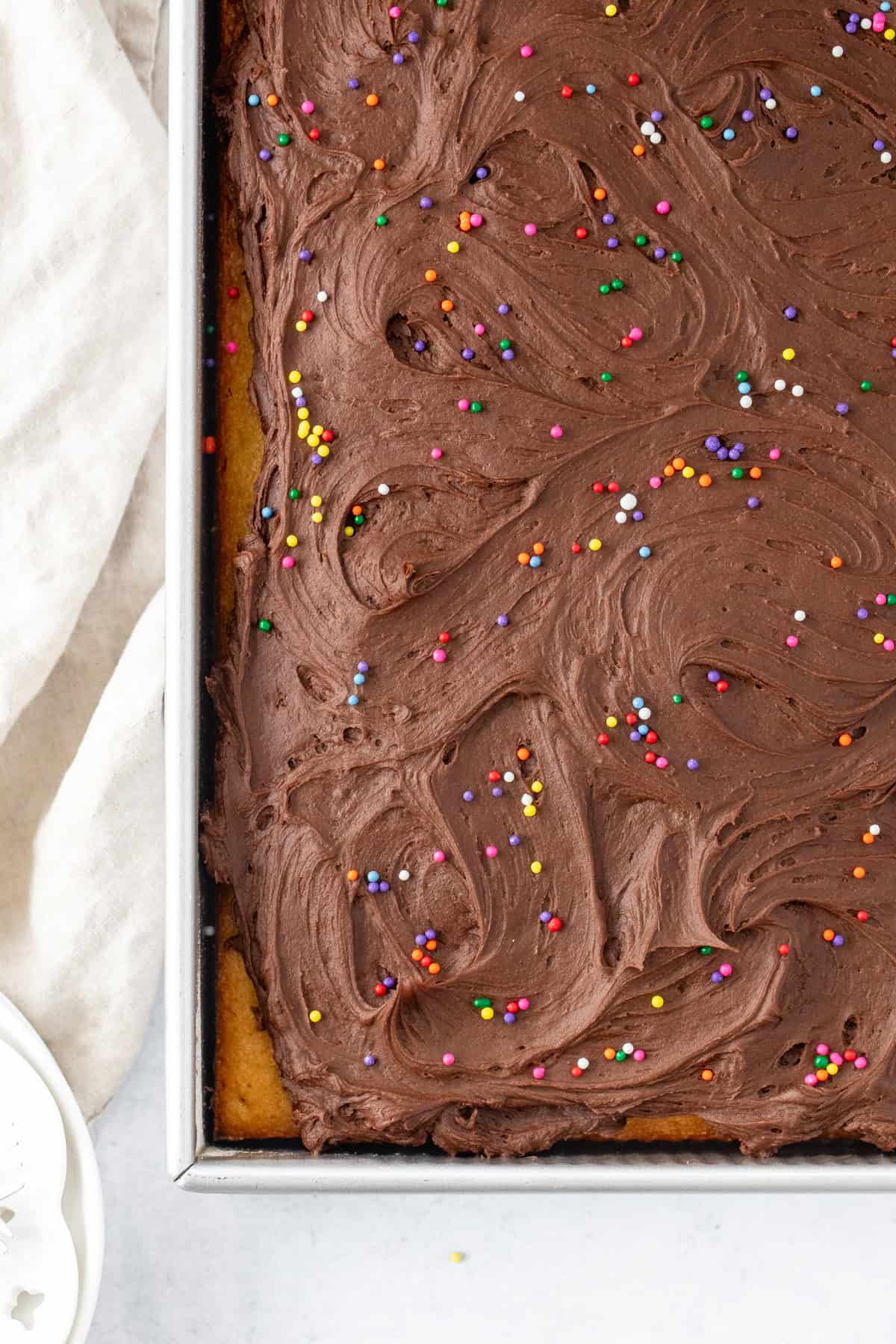 Sheet pan of yellow vanilla cake with chocolate frosting