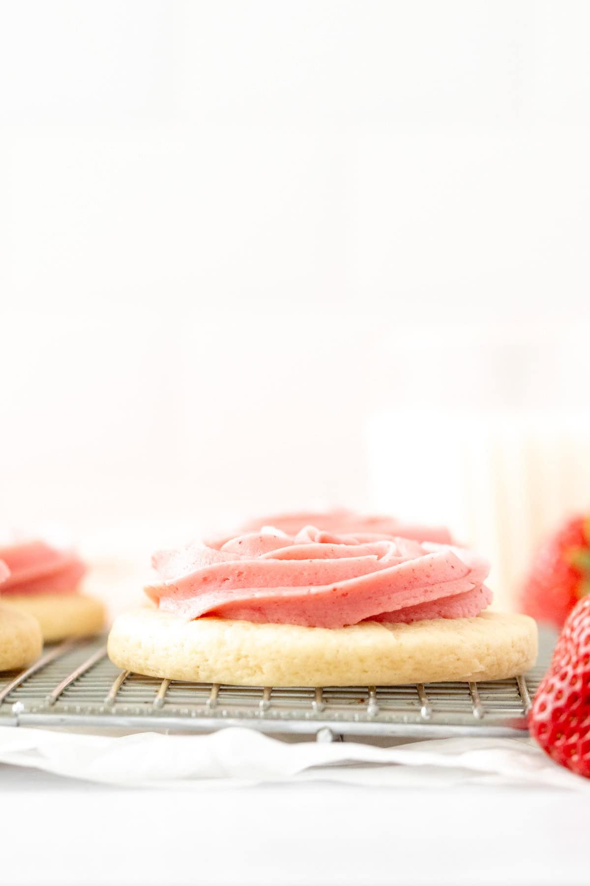 Cakey sugar cookie piped with strawberry buttercream frosting
