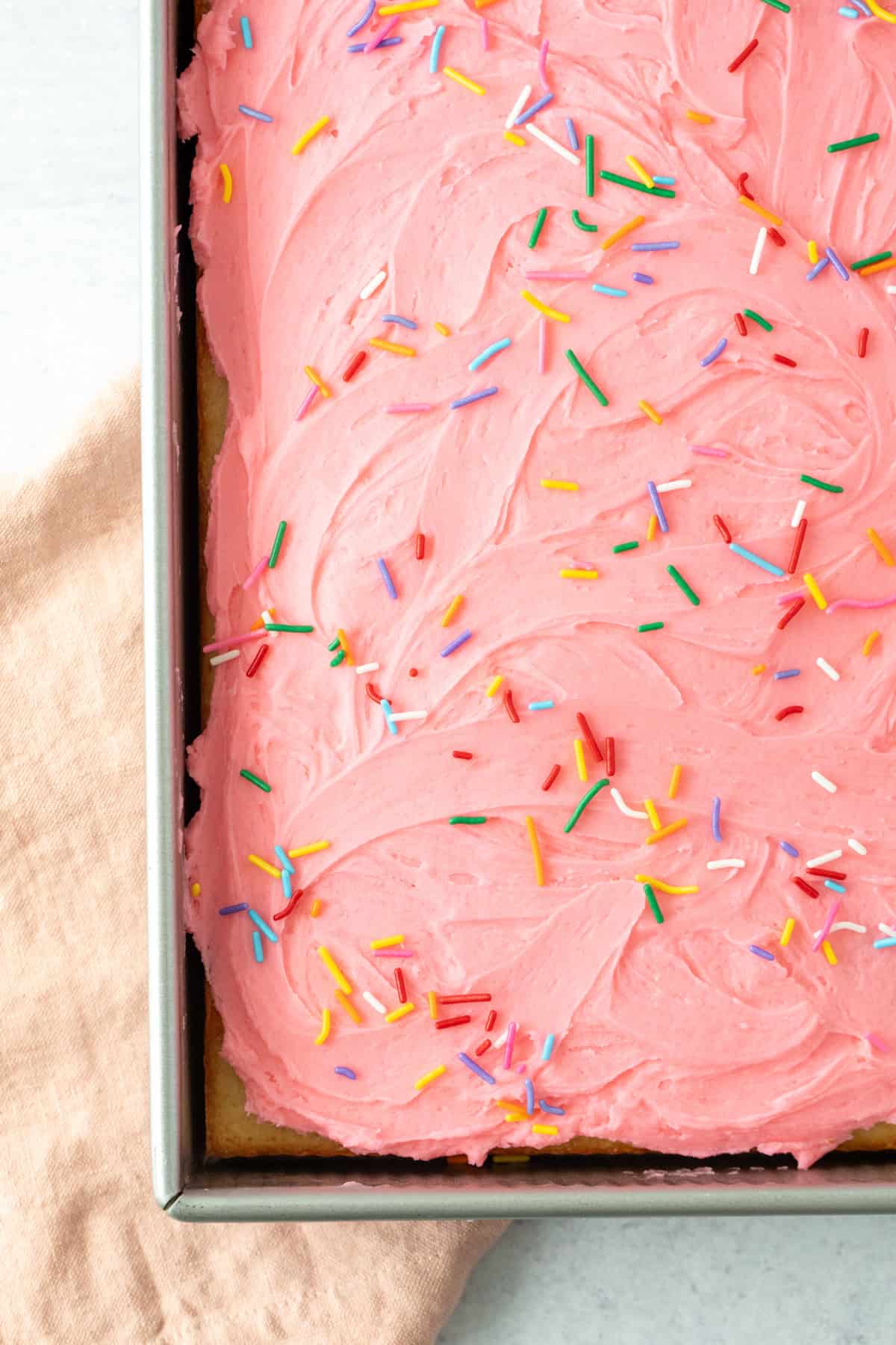 9x13 inch pan of vanilla sheet cake with pink frosting