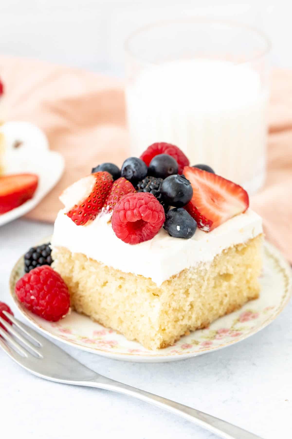 slice of vanilla cake topped with whipped cream and fresh berries