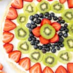 fruit pizza with sugar cookie crust, cream cheese frosting and fresh fruit