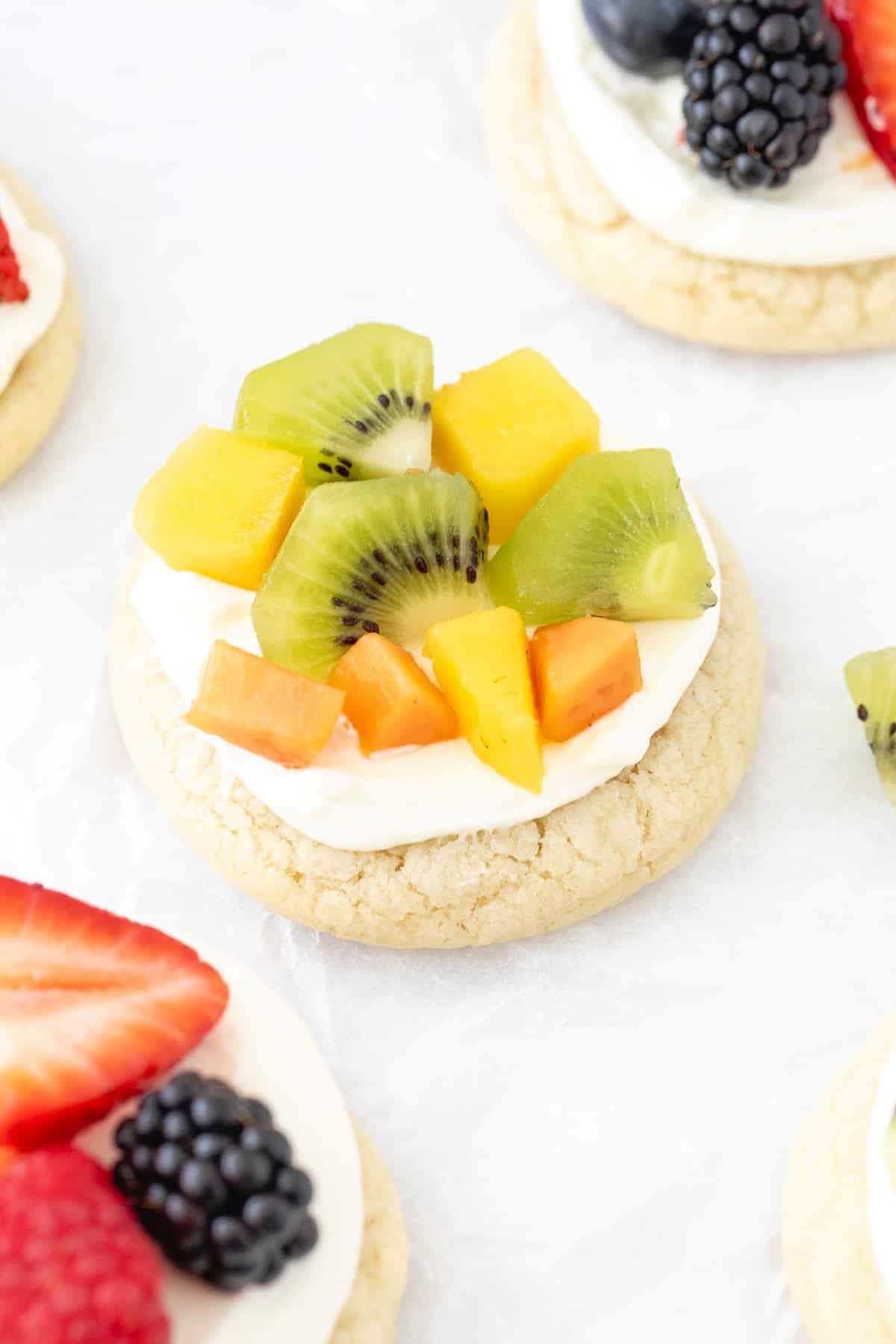 Mini fruit pizza with cream cheese frosting and tropical fruit on top