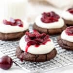 black forest cookies with whipped cream and cherry sauce on a cooling rack