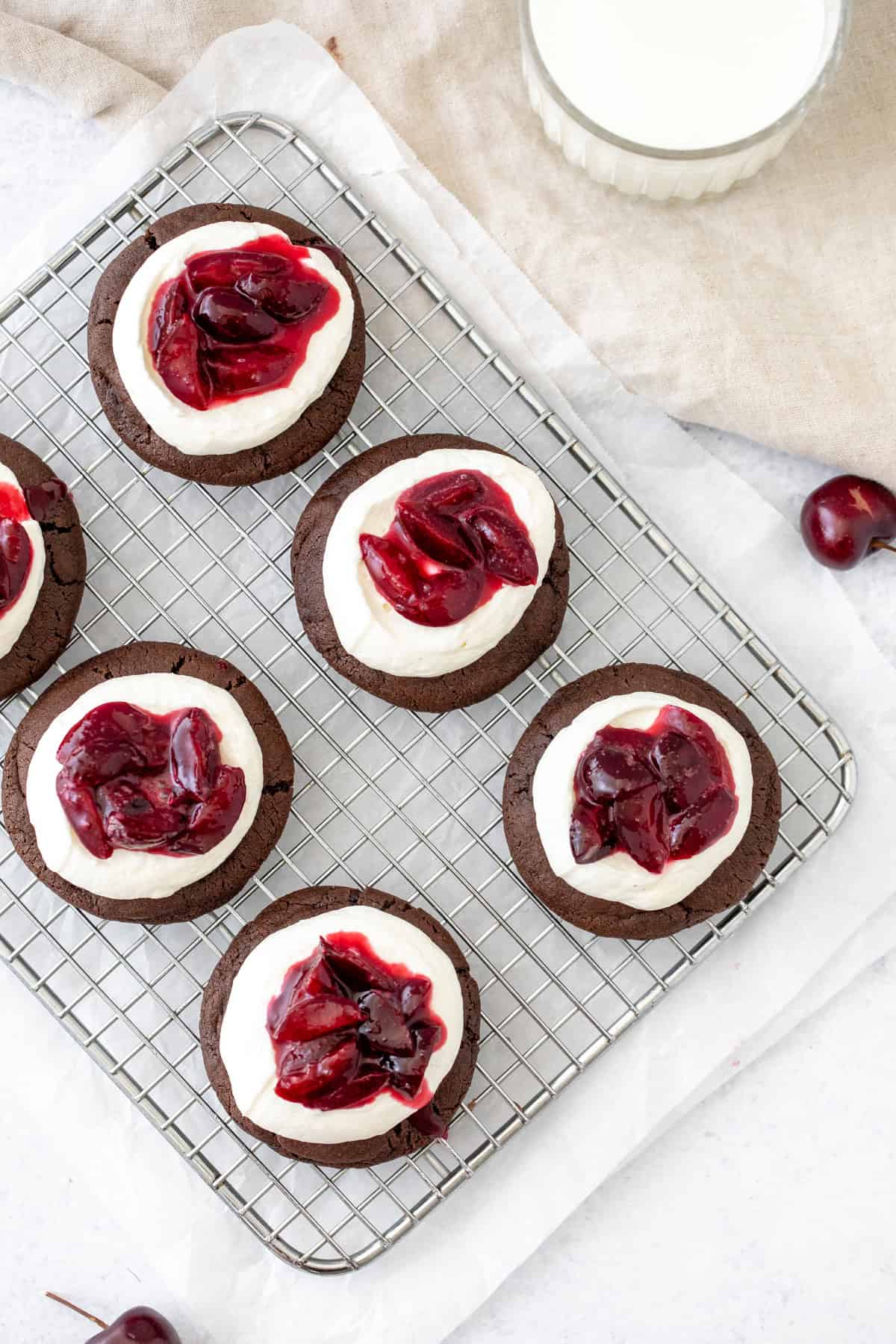Chocolate cookies topped with whipped cream and cherry sauce