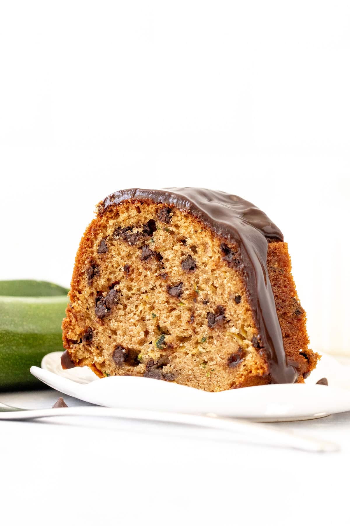 slice of chocolate chip zucchini cake with chocolate ganache on top